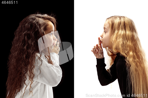 Image of The young teen girls whispering a secret behind her hand over pink background