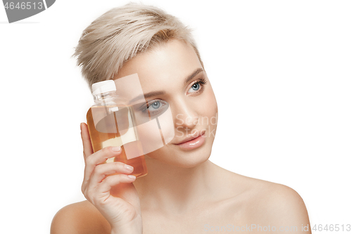 Image of Beauty concept. The pretty woman with perfect skin holding oil bottle