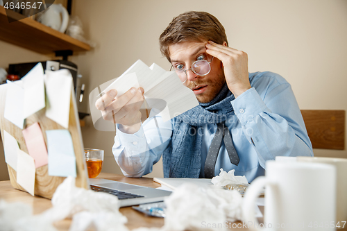 Image of Sick man while working in office, businessman caught cold, seasonal flu.