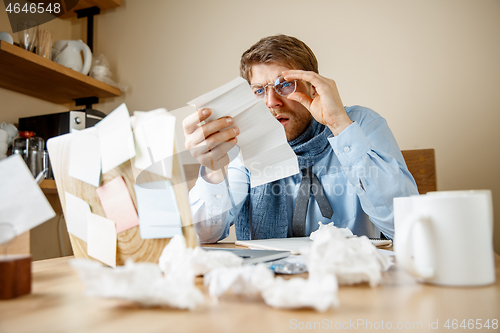 Image of Sick man while working in office, businessman caught cold, seasonal flu.