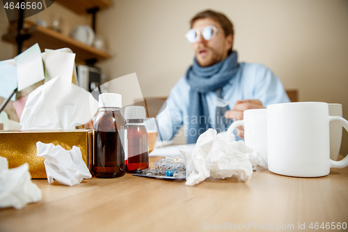 Image of Sick man while working in office, businessman caught cold, seasonal flu.