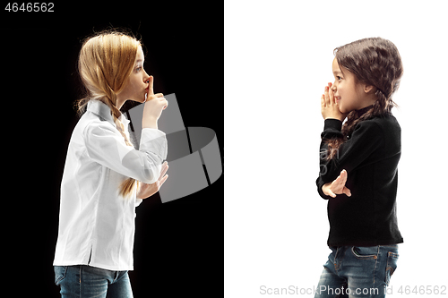 Image of The young teen girls whispering a secret behind her hand over pink background