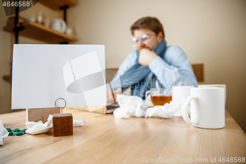 Image of Sick man while working in office, businessman caught cold, seasonal flu.