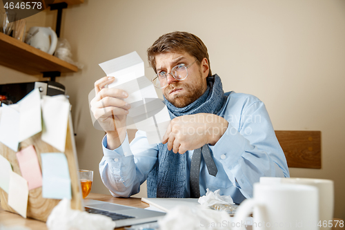 Image of Sick man while working in office, businessman caught cold, seasonal flu.