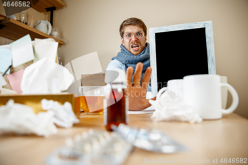 Image of Sick man while working in office, businessman caught cold, seasonal flu.