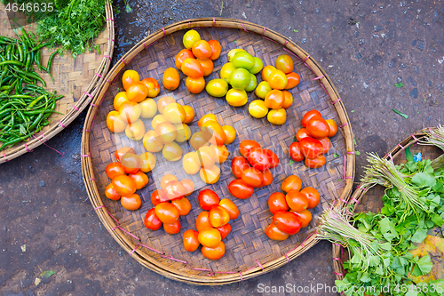 Image of Fresh red tomatoes in basket beeing sold on local asian farmers market