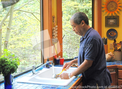 Image of Man washing dishes.