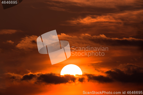 Image of sunset with sun over clouds