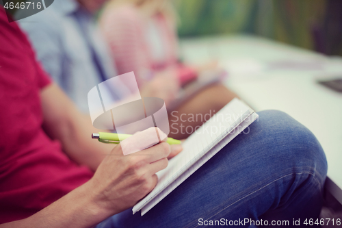 Image of male student taking notes in classroom