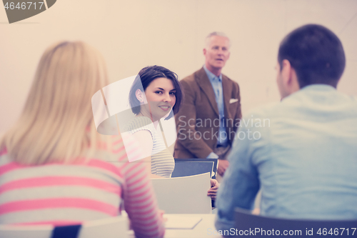 Image of teacher with a group of hi school students in classroom