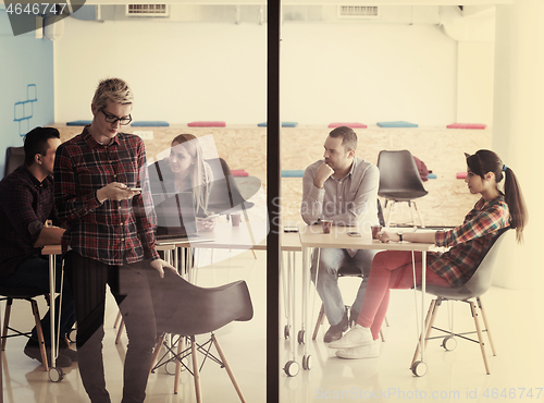 Image of business woman at office speaking by phone  team on meeting in b