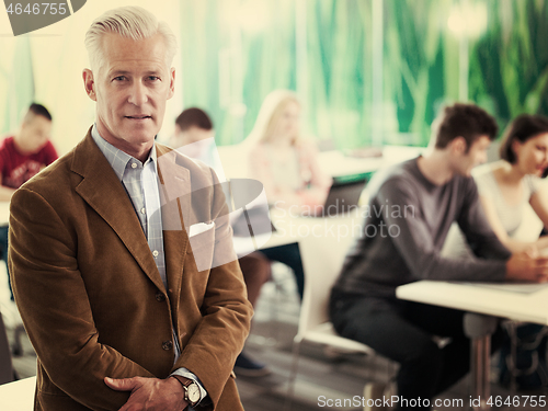 Image of portrait of in teacher in classroom with students group in backg