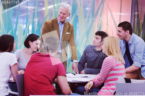 Image of teacher with a group of students in classroom