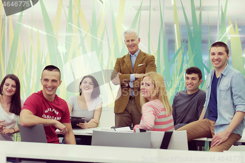 Image of portrait of  teacher with students group in background