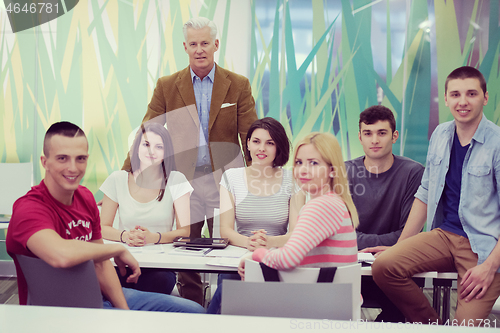 Image of portrait of  teacher with students group in background