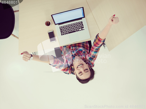 Image of top view of young business woman working on laptop