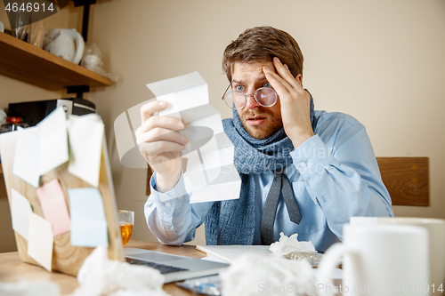 Image of Sick man while working in office, businessman caught cold, seasonal flu.