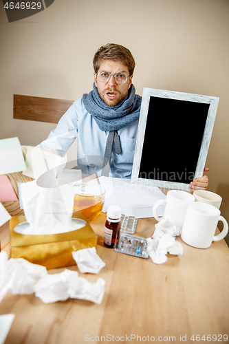 Image of Sick man while working in office, businessman caught cold, seasonal flu.