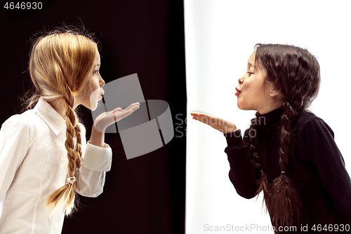 Image of portrait of two happy girls on a white and black background