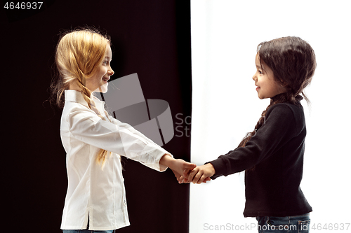 Image of portrait of two happy girls on a white and black background