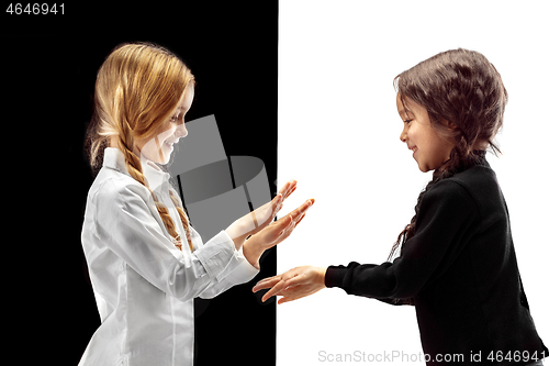 Image of portrait of two happy girls on a white and black background