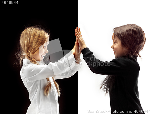 Image of portrait of two happy girls on a white and black background