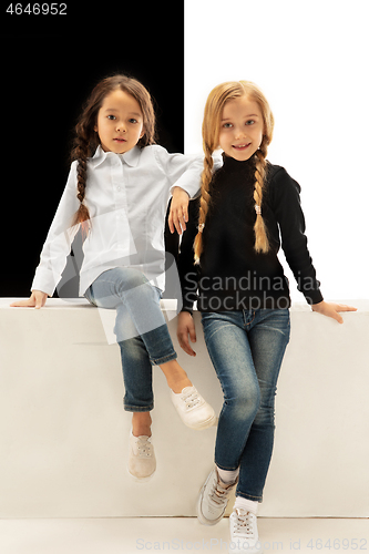 Image of portrait of two happy girls on a white and black background