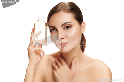 Image of Beauty concept. The pretty woman with perfect skin holding oil bottle