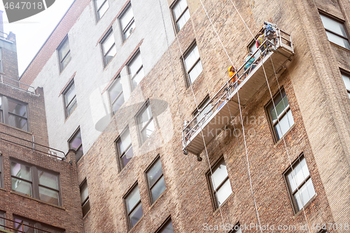 Image of workers hanging on a house facade in New York