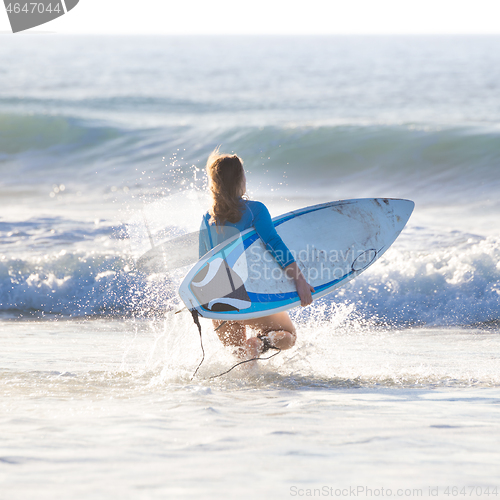 Image of Silhouette of surfer on beach with surfboard.