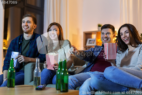 Image of friends with beer and popcorn watching tv at home