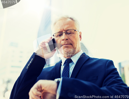 Image of senior businessman calling on smartphone in city