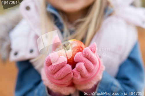 Image of close up of little girl holding apple in autumn