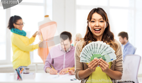 Image of asian woman with money over fashion design studio