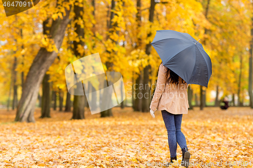 Image of young woman with umbrella in autumn park