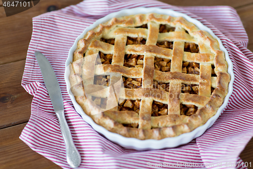 Image of close up of apple pie in baking mold and knife