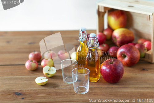 Image of glasses and bottles of apple juice on wooden table