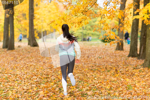 Image of young woman running in autumn park