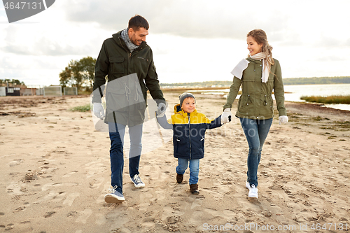 Image of happy family walking along autumn beach