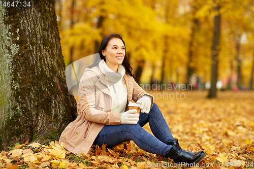 Image of woman drinking takeaway coffee in autumn park