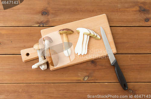 Image of edible mushrooms, kitchen knife and cutting board