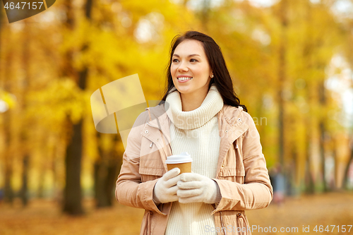 Image of woman drinking takeaway coffee in autumn park