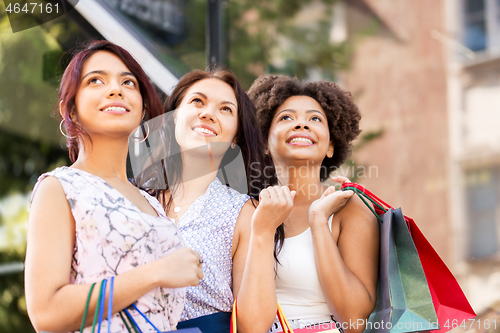 Image of happy women with shopping bags in city