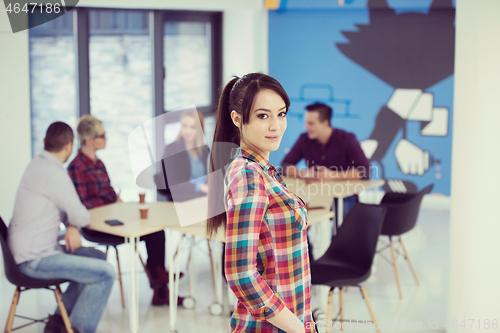 Image of portrait of young business woman at office with team in backgrou