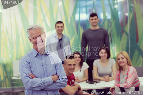Image of portrait of  teacher with students group in background