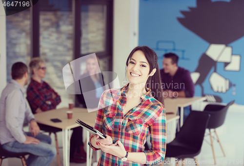 Image of portrait of young business woman at office with team in backgrou