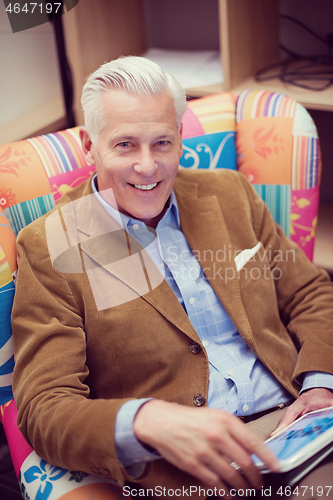 Image of portrait of handsome teacher in colorful chair