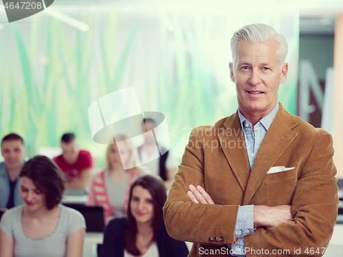 Image of portrait of in teacher in classroom with students group in backg