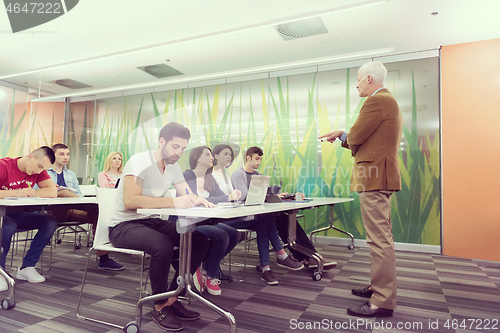 Image of teacher with a group of students in classroom