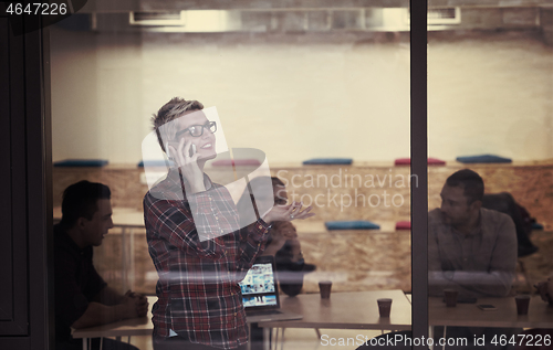 Image of business woman at office speaking by phone  team on meeting in b